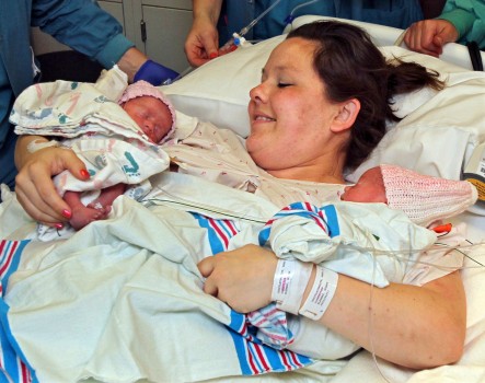 In this May 9, 2014 photo, Sarah Thistlethwaite holds her twin daughters, Jenna and Jillian, after her delivery of the monoamniotic twin girls at Akron General Hospital in Akron, Ohio. The identical twin girls shared the same amniotic sac and placenta, which doctors say occurs in about one of every 10,000 pregnancies. (AP Photo/Akron Beacon Journal, Ed Suba Jr.)