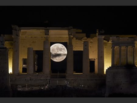 The 'Supermoon' rises behind the Propylaea above the Ancient Acropolis hill in Athens on November 14, 2016.  The moon will be the closest to Earth since 1948 at a distance of 356,509 kilometres (221,524 miles), creating what NASA described as "an extra-supermoon". / AFP PHOTO / ARIS MESSINIS
