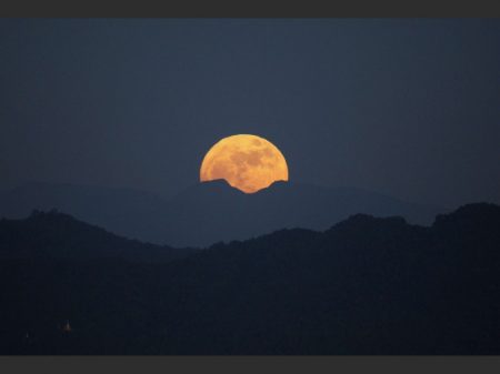 The moon rises behind the mountain range seen from Naypyitaw, Myanmar, Monday, Nov. 14, 2016. The brightest moon in almost 69 years lights up the sky in a treat for star watchers around the globe. The phenomenon is known as the supermoon. (AP Photo/Aung Shine Oo)/XAS101/16319465263707/1611141532