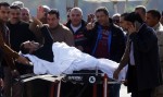Former Egyptian President Hosni Mubarak waves to his supporters from his stretcher as he returns to Maadi military hospital in Cairo