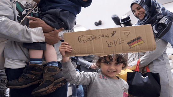 طفلة سورية تحمل لافتة "أحب ألمانيا"