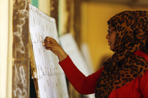 A Sudanese woman looks for her name on a list of voters at a school turned into a polling station on April 14, 2015 in Al-Jarif West, outside Khartoum on the second day of a three-day poll to elect a president and choose national and state lawmakers. Battling division and government repression, Sudan's opposition has launched a sit-in against elections expected to extend President Omar al-Bashir's rule, but it has been met with almost as much indifference as the vote itself. AFP PHOTO / ASHRAF SHAZLY (Photo credit should read ASHRAF SHAZLY/AFP/Getty Images)