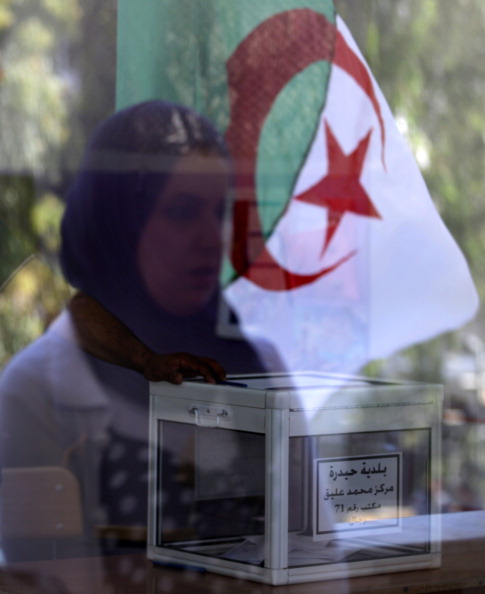 A ballot box sits on a table as a veiled woman and the Algerian national flag are reflected on the window of a classroom turned into a polling station for the presidential elections on April 17, 2014 in Algiers. Algeria's incumbent Presisdent Abdelaziz Bouteflika is widely expected to win despite his chronic health problems, warnings of fraud and opposition calls for a boycott. AFP PHOTO/PATRICK BAZ (Photo credit should read PATRICK BAZ/AFP/Getty Images)