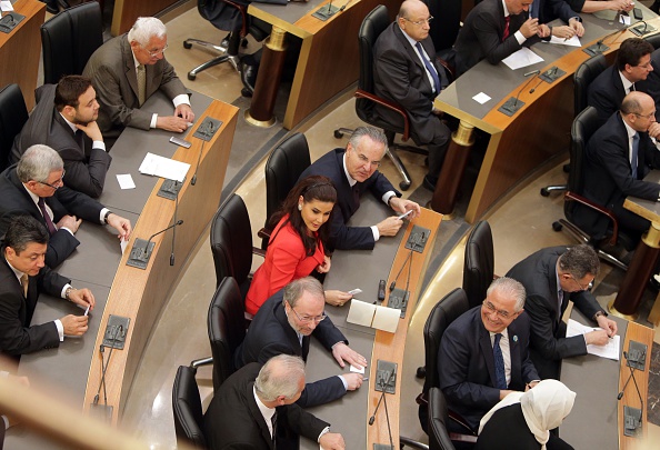 Lebanese member of parliament Sethrida Geagea (C in red) wife of presidential candidate Samir Geagea sits amongst fellow MPs as they cast their vote to elect the new Lebanese president in the parliament building in downtown Beirut on April 23, 2014. Lebanon's parliament failed to elect a new president, with no candidate securing the two-thirds of the vote needed to win and many lawmakers leaving their ballots blank. AFP PHOTO/JOSEPH EID/POOL (Photo credit should read JOSEPH EID/AFP/Getty Images)